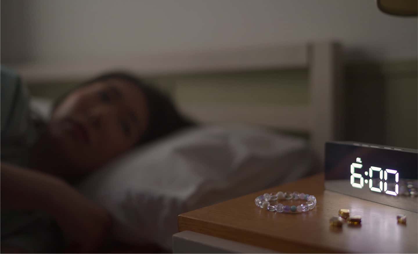Imagen de ejemplo con enfoque en un reloj en primer plano y una mujer con bokeh del fondo que ilustra una variación de longitud focal de enfoque mínima cuando el área de enfoque se cambia