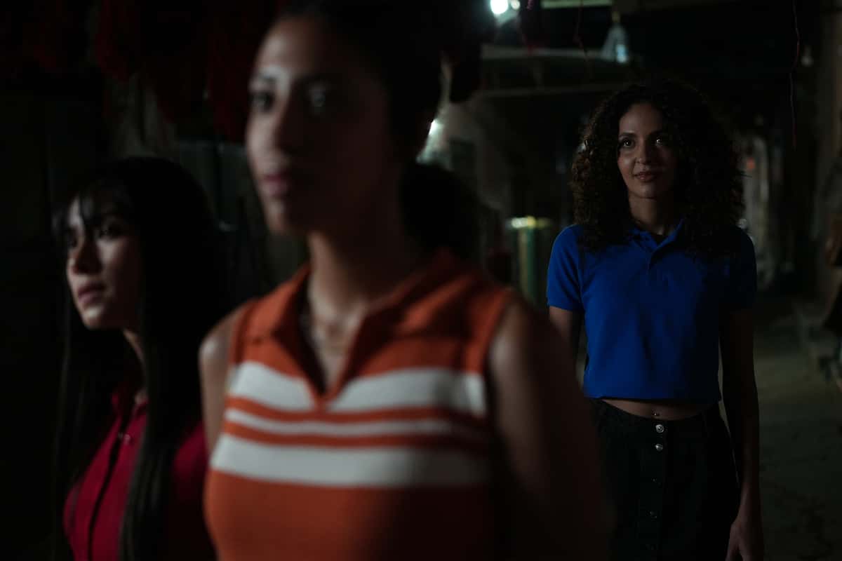 Imagen de ejemplo de tres mujeres en la oscuridad donde la que está más alejada de la cámara se ve enfocada nítidamente